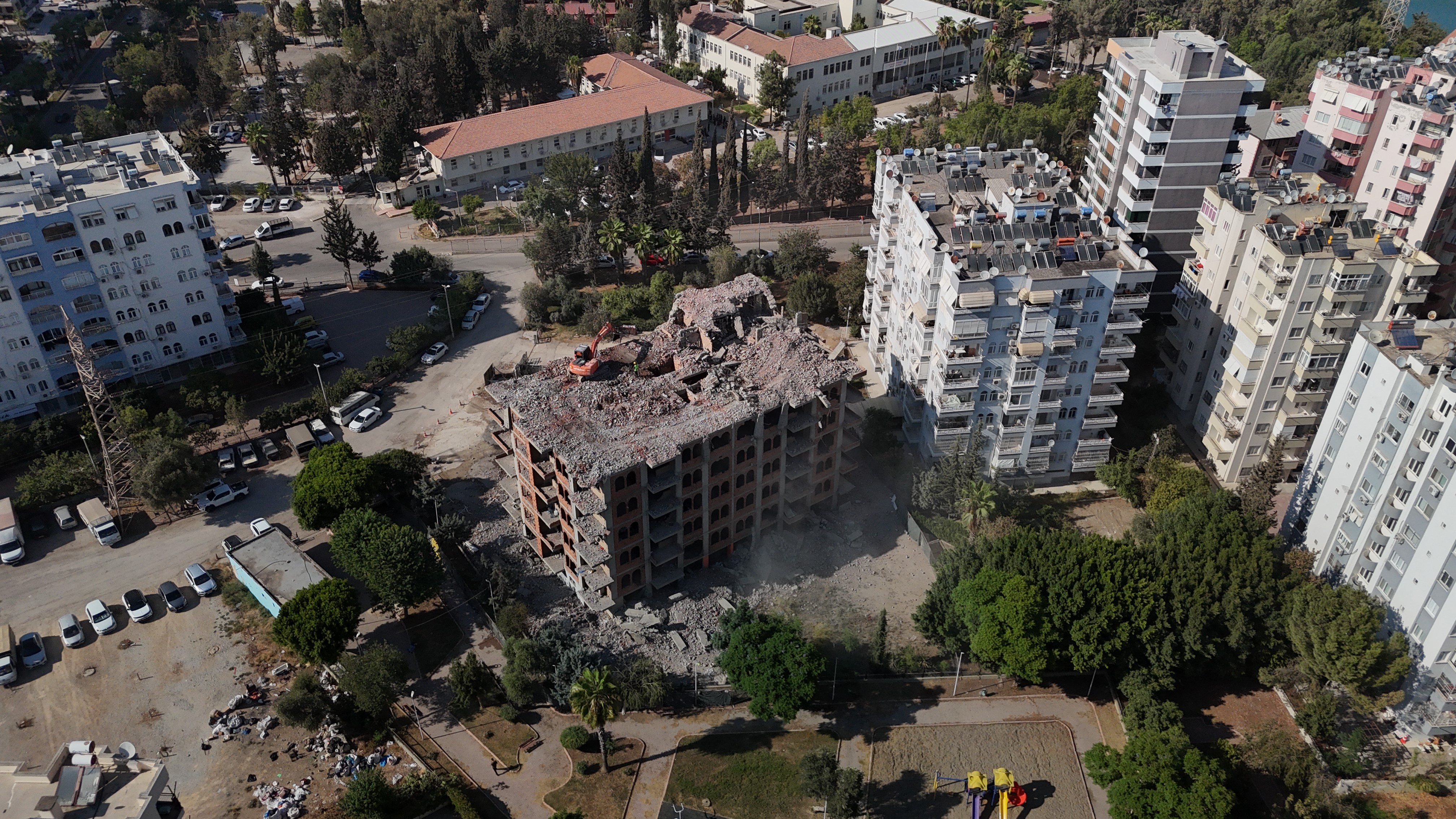 Adana'da yaklaşık 33 yıl önce inşaatına başlanan 11 katlı bina, damına iş makinesi çıkartılarak yıkılıyor