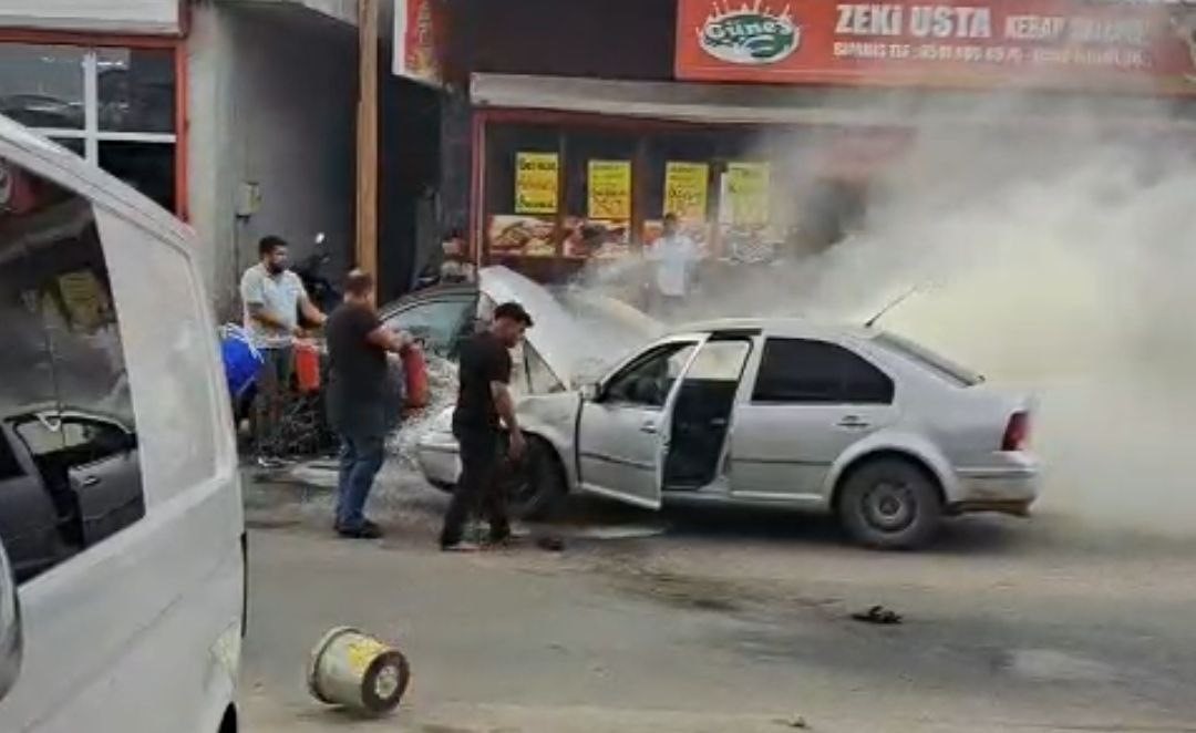Adana'da yanan otomobili esnaf su ve yangın tüpüyle söndürdü