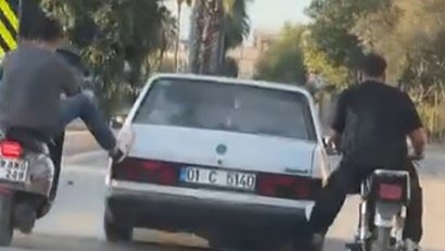 Motosikletliler, yolda kalan otomobili ayaklarıyla ittirdi
