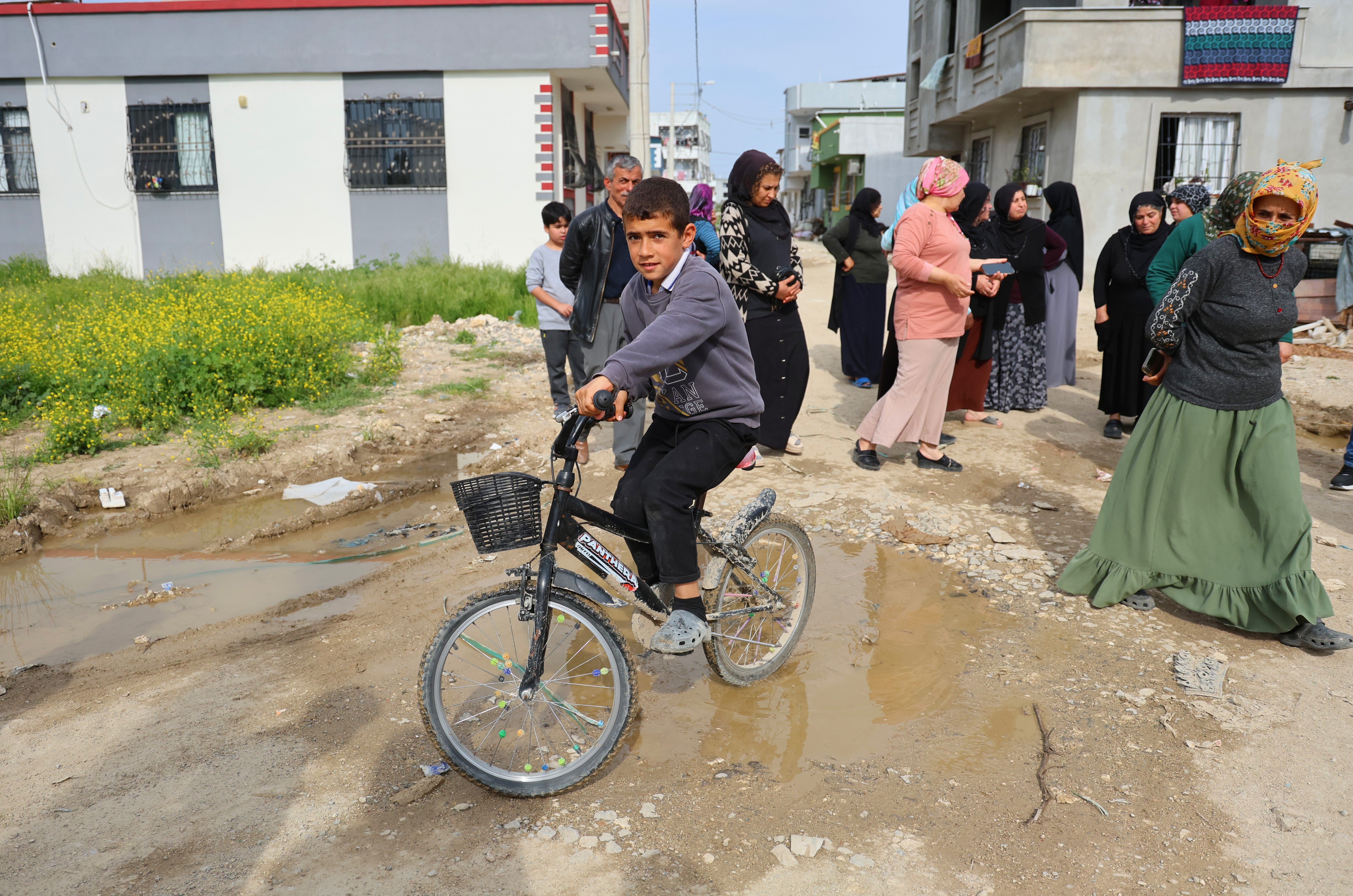 Adana'da altyapı ve yol sorunu yaşandığı belirtilen mahallede bir anne, engelli evladıyla eylem yaptı