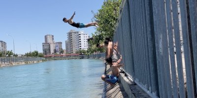 Bayramda evde oturmaktan sıkılan gençler Adana'da yüzerek serinledi