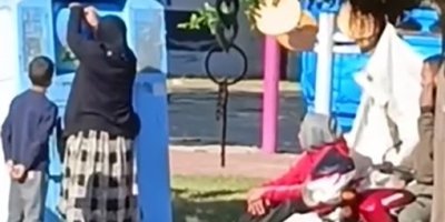 Giysi kumbarasına giren çocuk, topladığı kıyafetleri annesine verdi