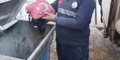 Temizlik işçisi yanmak üzere olan bayrağı çöpten aldı