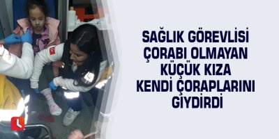 Sağlık görevlisi çorabı olmayan küçük kıza kendi çoraplarını giydirdi