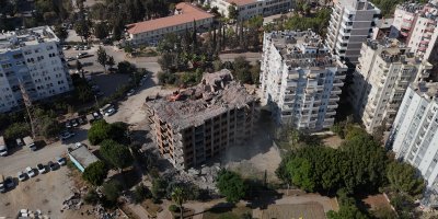 Adana'da yaklaşık 33 yıl önce inşaatına başlanan 11 katlı bina, damına iş makinesi çıkartılarak yıkılıyor
