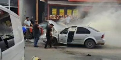 Adana'da yanan otomobili esnaf su ve yangın tüpüyle söndürdü