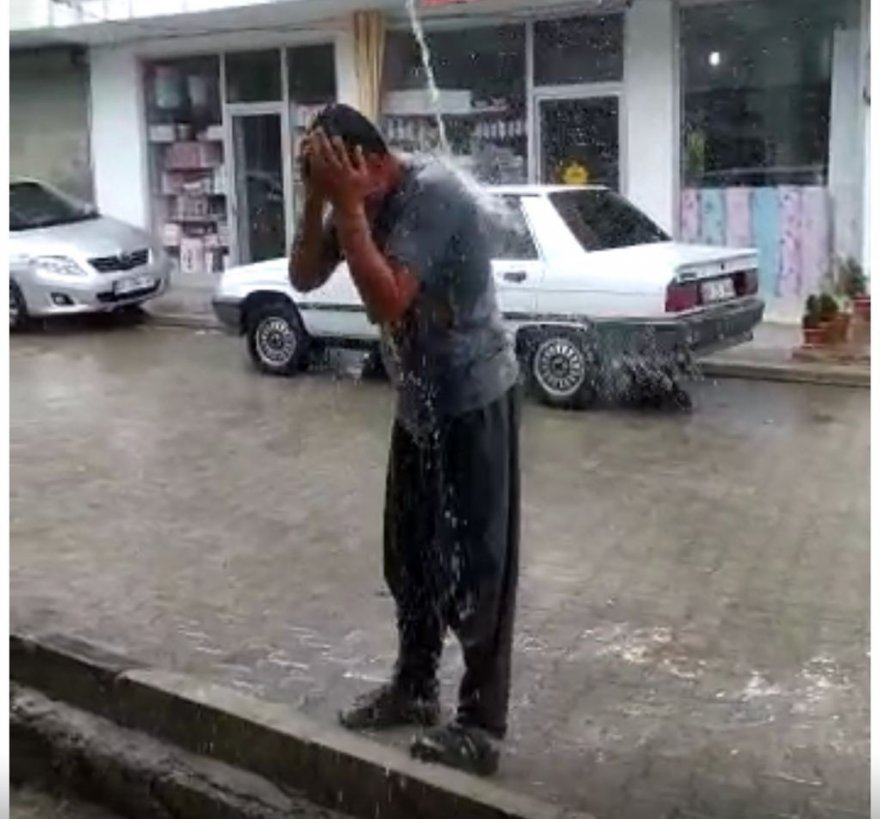 Ağustos’ta yağan yağmur altında banyo yaptı