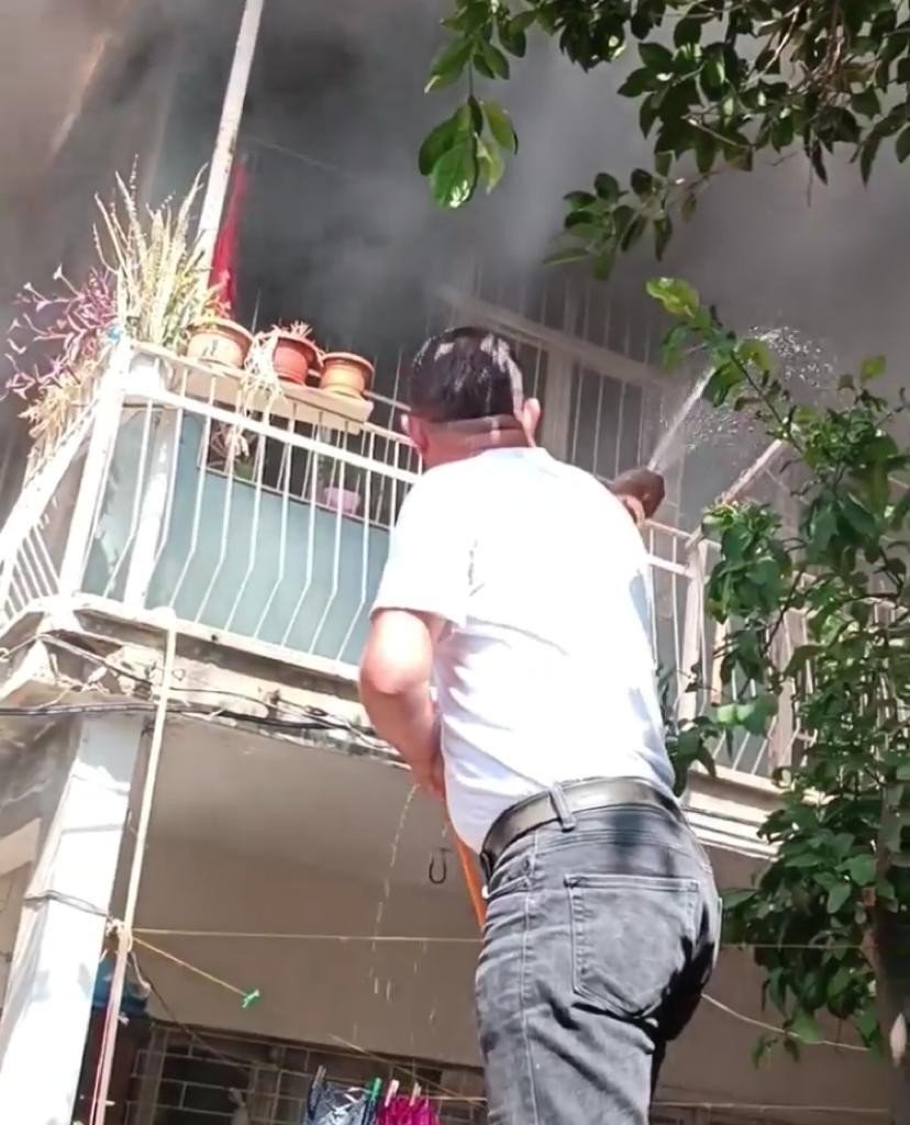 Yanan evi hortumla söndürmeye çalıştı